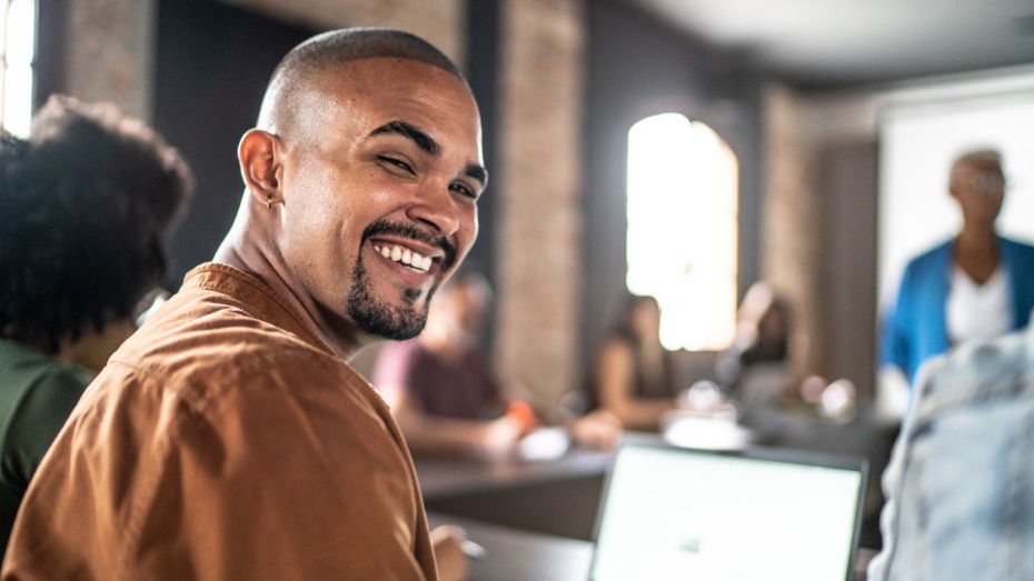 Jovem negro sorrindo em sala de aula
