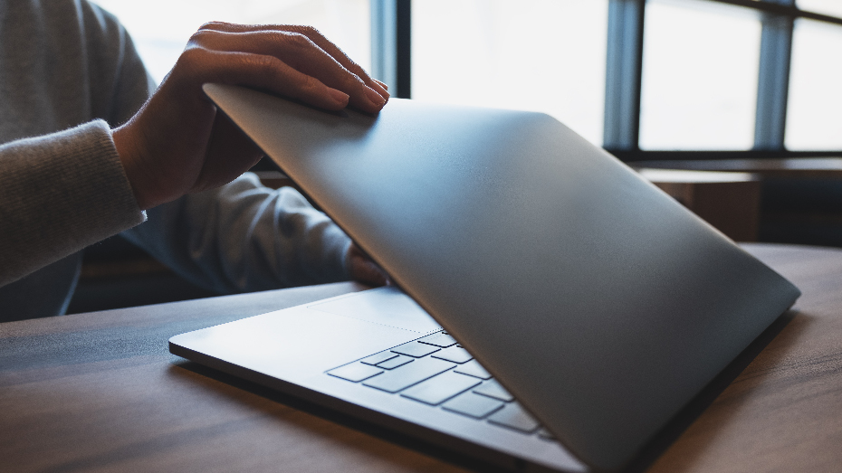Foto de um colaborador fechando o notebook e indo aproveitar seu dia extra de folga, já que sua empresa implementou a semana de 4 dias.
