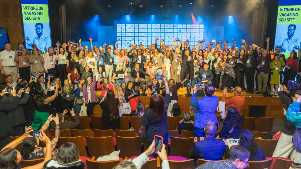 Foto do palco lotado recebendo o prêmio troféu ponte para o trabalho