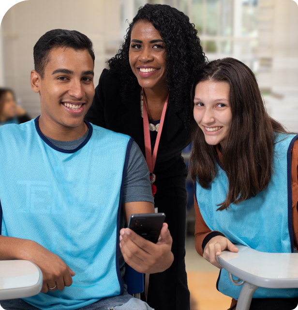 Jovens aprendiz, duas moças e um rapaz sorrindo olhando para o celular